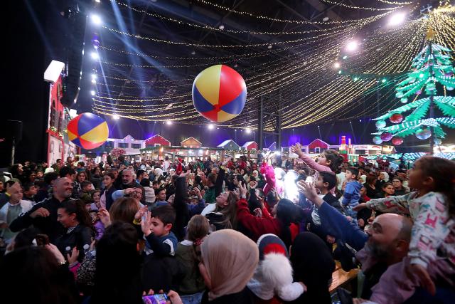 (251213) -- BEIRUT, Dec. 13, 2025 (Xinhua) -- This photo taken on Dec. 12, 2025 shows people enjoying the Christmas atmosphere at a Christmas fair in Beirut, Lebanon. The Christmas fair, or the 13th session of the annual "Christmas In Action," runs from Dec. 12 to Dec. 23. (Photo by Bilal Jawich/Xinhua)