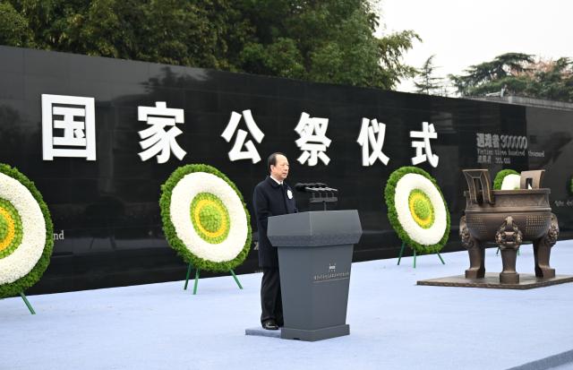 (251213) -- NANJING, Dec. 13, 2025 (Xinhua) -- Shi Taifeng, a member of the Political Bureau of the Communist Party of China (CPC) Central Committee and head of the CPC Central Committee's Organization Department, speaks while attending a national memorial ceremony to mourn the victims of the Nanjing Massacre in Nanjing, east China's Jiangsu Province, Dec. 13, 2025. The ceremony was held by the CPC Central Committee and the State Council at the public square of the Memorial Hall of the Victims in Nanjing Massacre by Japanese Invaders in Nanjing. (Xinhua/Li Xiang)