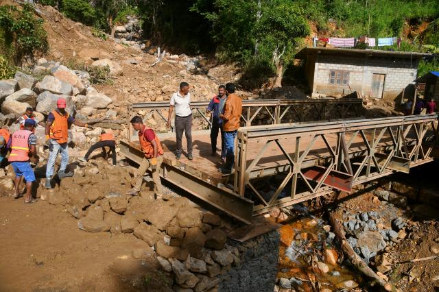 (251213) -- BADULLA, Dec. 13, 2025 (Xinhua) -- People repair a collapsed bridge affected by Cyclone Ditwah in Badulla District, Sri Lanka, Dec. 13, 2025. According to Sri Lanka's Disaster Management Center, the country recently suffered severe damage due to the extreme weather triggered by Cyclone Ditwah, which left more than 600 people dead, affected more than 2 million people, destroyed more than 4,000 houses and partially damaged more than 60,000 houses nationwide. (Photo by Ajith Perera/Xinhua)