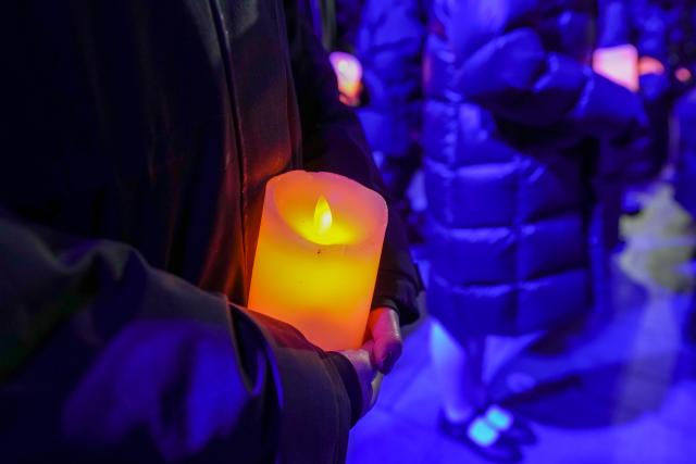 (251213) -- NANJING, Dec. 13, 2025 (Xinhua) -- People attend a candle-light vigil at the Memorial Hall of the Victims in Nanjing Massacre by Japanese Invaders in Nanjing, capital of east China's Jiangsu Province, Dec. 13, 2025. A candle-light vigil was held at the memorial hall on Saturday, which was the 12th national memorial day for the victims of the Nanjing Massacre. (Xinhua/Li Bo)