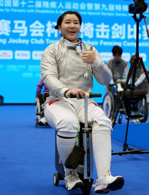 (251213) -- HONG KONG, Dec. 13, 2025 (Xinhua) -- Yu Chui Yee of Hong Kong team 1 poses prior to the women's sabre individual category A wheelchair fencing at China's 12th National Games for Persons with Disabilities and the 9th National Special Olympic Games in Hong Kong, south China, Dec. 13, 2025. (Xinhua/Hou Zhaokang)