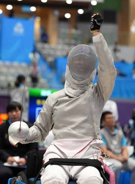 (251213) -- HONG KONG, Dec. 13, 2025 (Xinhua) -- Chen Yuandong of Shanghai celebrates during the women's sabre individual category A wheelchair fencing at China's 12th National Games for Persons with Disabilities and the 9th National Special Olympic Games in Hong Kong, south China, Dec. 13, 2025. (Xinhua/Hou Zhaokang)