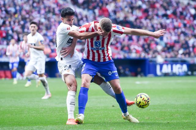 (251214) -- MADRID, Dec. 14, 2025 (Xinhua) -- Atletico de Madrid's Alexander Sorloth (R) vies with Valencia C.F.'s Eray Comert during the Laliga football match between Atletico de Madrid and Valencia C.F. in Madrid, Spain, Dec. 13, 2025. (Photo by Gustavo Valiente/Xinhua)