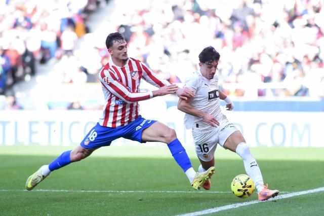 (251214) -- MADRID, Dec. 14, 2025 (Xinhua) -- Atletico de Madrid's Marc Pubill (L) vies with Valencia C.F.'s Diego Lopez during the Laliga football match between Atletico de Madrid and Valencia C.F. in Madrid, Spain, Dec. 13, 2025. (Photo by Gustavo Valiente/Xinhua)