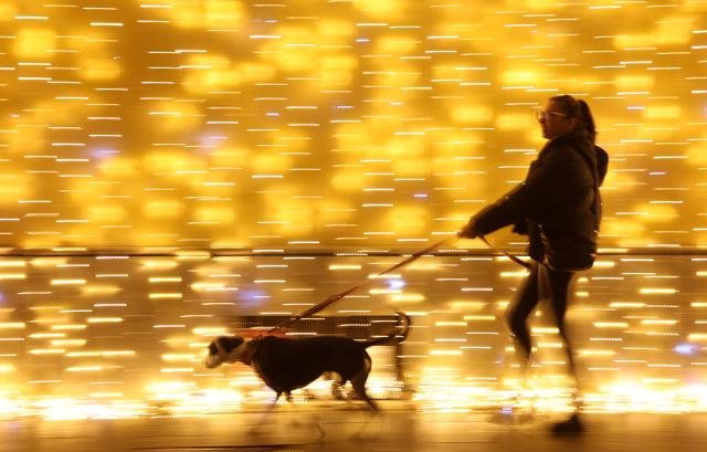 (251214) -- ROME, Dec. 14, 2025 (Xinhua) -- A woman walks her dog near Piazza del Popolo in Rome, Italy, Dec. 13, 2025. (Xinhua/Li Jing)