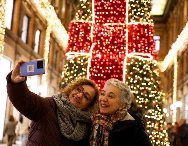 (251214) -- ROME, Dec. 14, 2025 (Xinhua) -- People take selfies with festive lights at Galleria Alberto Sordi in Rome, Italy, Dec. 13, 2025. (Xinhua/Li Jing)