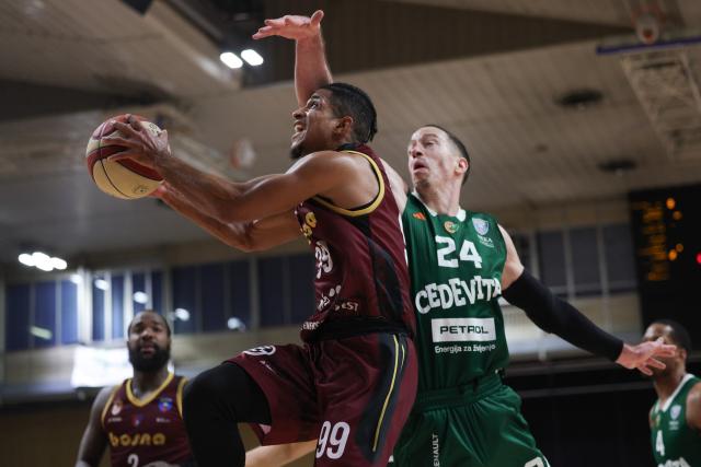 (251214) -- LJUBLJANA, Dec. 14, 2025 (Xinhua) -- Alfonso Plummer (C) of Bosna BH Telekom goes for a layup against David Skara of Cedevita Olimpija during the 10th round match between Cedevita Olimpija and Bosna BH Telekom at the AdmiralBet ABA Basketball League 2025/26 in Ljubljana, Slovenia, Dec. 13, 2025. (Photo by Zeljko Stevanic/Xinhua)