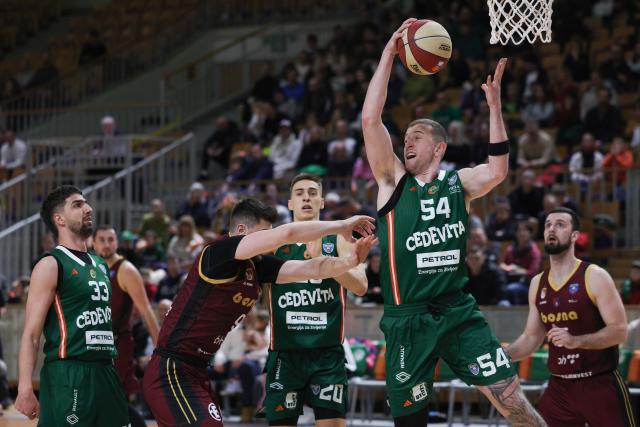 (251214) -- LJUBLJANA, Dec. 14, 2025 (Xinhua) -- Thomas Kennedy (top) of Cedevita Olimpija grabs a rebound during the 10th round match between Cedevita Olimpija and Bosna BH Telekom at the AdmiralBet ABA Basketball League 2025/26 in Ljubljana, Slovenia, Dec. 13, 2025. (Photo by Zeljko Stevanic/Xinhua)