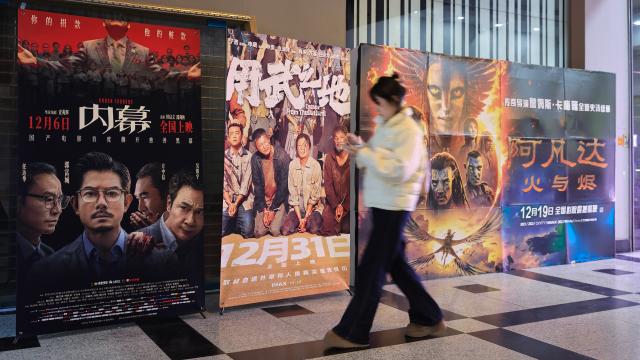 (251214) -- BEIJING, Dec. 14, 2025 (Xinhua) -- A woman walks past movie posters at a movie theater in Nanjing, east China's Jiangsu Province, Dec. 13, 2025.
  As of 2:30 p.m. on Saturday, China's 2025 box office revenue had surpassed 50 billion yuan (about 7.08 billion U.S. dollars), according to the China Film Administration. (Photo by Su Yang/Xinhua)