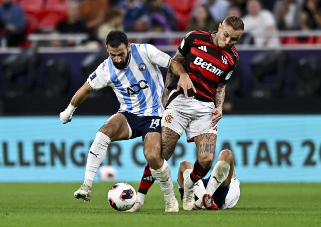 (251214) -- DOHA, Dec. 14, 2025 (Xinhua) -- Everton (C) of CR Flamengo vies with Mohanad Lasheen (L) of Pyramids FC during the FIFA Challenger Cup 2025 match between Brazil's CR Flamengo and Egypt's Pyramids FC, part of the FIFA Intercontinental Cup 2025 in Doha, Qatar, on Dec. 13, 2025. (Photo by Nikku/Xinhua)