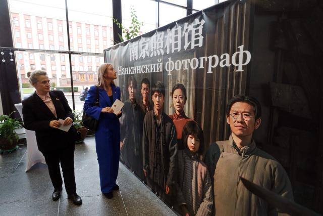 (251214) -- MINSK, Dec. 14, 2025 (Xinhua) -- People view a poster of the Chinese historical film "Dead To Rights" in Minsk, Belarus, Dec. 12, 2025.
  TO GO WITH "Feature: Remembering Nanjing Massacre -- Belarusians, Chinese unite in grief and hope at film premiere" (Photo by Henadz Zhinkov/Xinhua)
