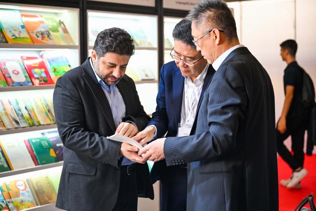 (251214) -- ISTANBUL, Dec. 14, 2025 (Xinhua) -- Two Chinese publishers introduce Chinese books to a Turkish publisher at the 42nd Istanbul International Book Fair in Istanbul, Türkiye, Dec. 13, 2025. The book fair opened on Saturday in Istanbul, Türkiye's largest city. The Chinese publishing delegation showcased over 700 high-quality books at the book fair, attracting many local readers. (Xinhua/Liu Lei)