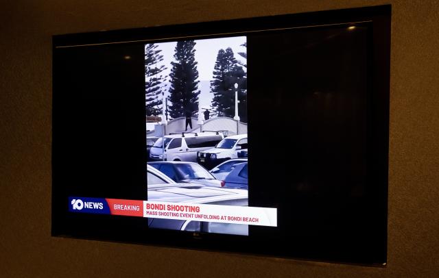 (251214) -- SYDNEY, Dec. 14, 2025 (Xinhua) -- This photo taken on Dec. 14, 2025 shows the TV news reporting a mass shooting at Bondi Beach in Sydney, Australia. At least 12 people have died after a shooting at Sydney's Bondi Beach on Sunday night, said New South Wales Premier Chris Minns.
   One of the offenders was among the dead and another one is in custody, the Australian Broadcasting Corporation (ABC) cited Minns as saying. (Xinhua/Ma Ping)