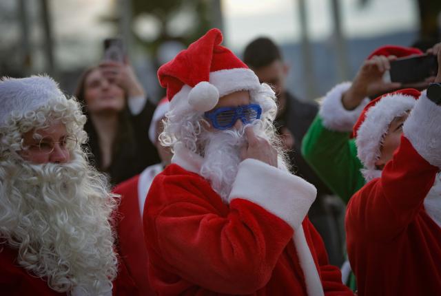 (251214) -- VANCOUVER, Dec. 14, 2025 (Xinhua) -- People dressed as Santa Claus attend the annual SantaCon event in Vancouver, Canada, Dec. 13, 2025. The annual event is held here on Saturday, with participants dressed as Santa Claus and other holiday characters moving at different locations and bringing a festive atmosphere and holiday cheer to the streets. (Photo by Liang Sen/Xinhua)