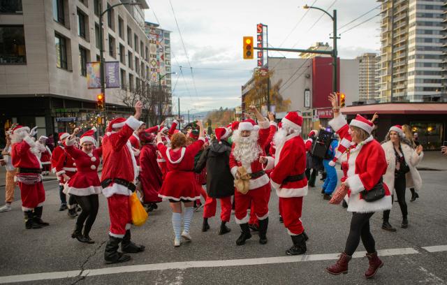 (251214) -- VANCOUVER, Dec. 14, 2025 (Xinhua) -- People dressed as Santa Claus attend the annual SantaCon event in Vancouver, Canada, Dec. 13, 2025. The annual event is held here on Saturday, with participants dressed as Santa Claus and other holiday characters moving at different locations and bringing a festive atmosphere and holiday cheer to the streets. (Photo by Liang Sen/Xinhua)