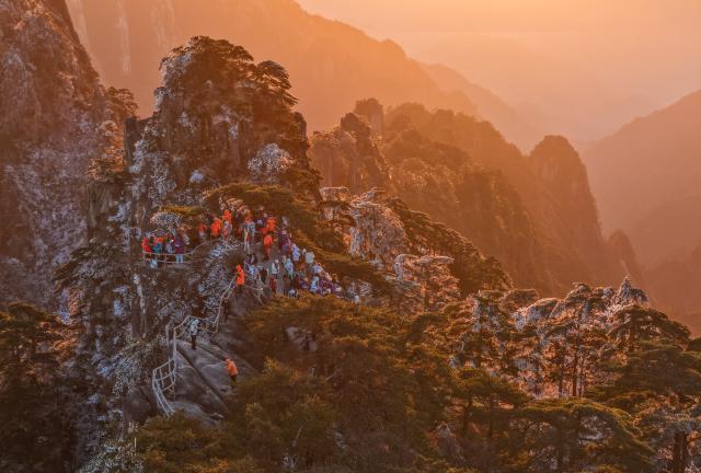 (251214) -- HUANGSHAN, Dec. 14, 2025 (Xinhua) -- An aerial drone photo taken on Dec. 14, 2025 shows tourists enjoying the scenery of the Huangshan Mountain scenic area at sunrise after snow, in east China's Anhui Province. (Photo by Shi Yalei/Xinhua)
