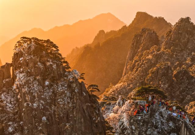 (251214) -- HUANGSHAN, Dec. 14, 2025 (Xinhua) -- An aerial drone photo taken on Dec. 14, 2025 shows tourists enjoying the scenery of the Huangshan Mountain scenic area at sunrise after snow, in east China's Anhui Province. (Photo by Shi Yalei/Xinhua)