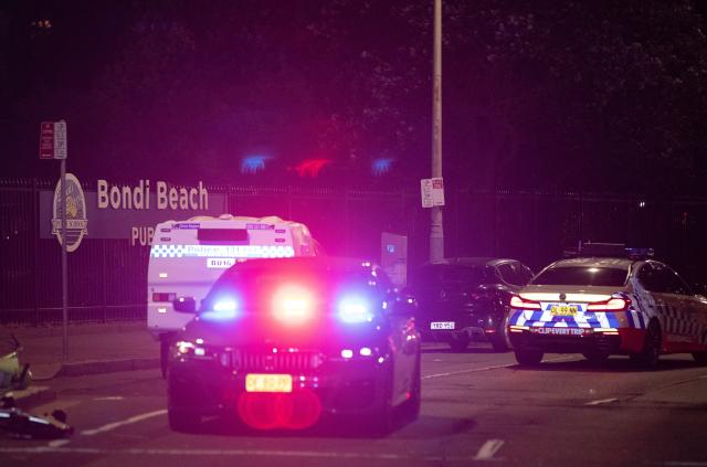 (251214) -- SYDNEY, Dec. 14, 2025 (Xinhua) -- Police vehicles are seen near the shooting site at Bondi Beach in Sydney, Australia, on Dec. 14, 2025. At least 12 people have died after a shooting at Sydney's Bondi Beach on Sunday night, said New South Wales Premier Chris Minns.
   One of the offenders was among the dead and another one is in custody, the Australian Broadcasting Corporation (ABC) cited Minns as saying. (Xinhua/Ma Ping)