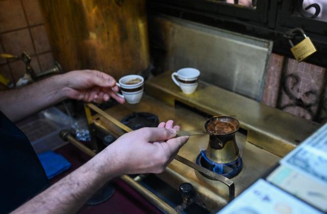 (251214) -- ISTANBUL, Dec. 14, 2025 (Xinhua) -- Can Ozmen, owner of the Turkish cafe Mandabatmaz, makes Turkish coffee at his cafe in Istanbul, Türkiye, Nov. 22, 2025.
  Mandabatmaz, a Turkish cafe, is located in a small alley beside Istiklal Avenue in Istanbul.
  The owner, Can Ozmen, took over this small coffee shop with a history of nearly sixty years from his parents. To carry on the tradition, he still insists on brewing coffee with copper pots. Ozmen introduced that Turkish coffee should be consumed with coffee grounds, which makes Turkish coffee unique. "Unlike other coffees, which are filtered, Turkish coffee is enjoyed in its entirety," Ozmen explained.
  Turkish coffee has a long history and was inscribed on UNESCO's Representative List of the Intangible Cultural Heritage of Humanity in 2013.
  While in China, a riverside cafe in Yunnan also wins fame among coffee lovers.
  Li Jinhe, 53, has operated his cafe in Mangkuan under Baoshan City in Gaoligong Mountains for 14 years.
  His "flame-brewed coffee", which made by a blowtorch to heat beneath siphon pots, has taken the Internet by storm for its originality, turning his cafe into a viral sensation.
  Tourists said that the coffee shop by the Nujiang River has broken the stereotype of urban coffee, and coffee should be a daily drink integrated into life.
  "I grew up here, and love Gaoligong Mountains," said Li. The Gaoligong Mountains, where fertile soil, ideal temperatures and abundant sunlight situate it within the global coffee-growing belt, boast small-bean coffee. "It is my unwavering commitment to promote local small-bean coffee," added Li.
  Although made by different ways, both Turkish and Chinese coffee tell the story of people's pursuit of life with warmth and aroma. (Xinhua/Liu Lei)