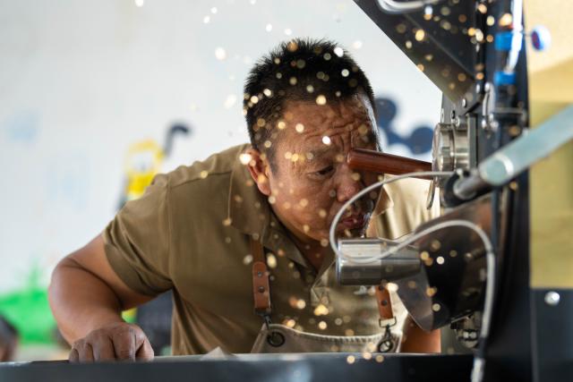 (251214) -- KUNMING, Dec. 14, 2025 (Xinhua) -- Li Jinhe works at a coffee bean processing workshop in Tangxi Village of Mangkuan Township, Baoshan City, southwest China's Yunnan Province, Nov. 15, 2025.
  Mandabatmaz, a Turkish cafe, is located in a small alley beside Istiklal Avenue in Istanbul.
  The owner, Can Ozmen, took over this small coffee shop with a history of nearly sixty years from his parents. To carry on the tradition, he still insists on brewing coffee with copper pots. Ozmen introduced that Turkish coffee should be consumed with coffee grounds, which makes Turkish coffee unique. "Unlike other coffees, which are filtered, Turkish coffee is enjoyed in its entirety," Ozmen explained.
  Turkish coffee has a long history and was inscribed on UNESCO's Representative List of the Intangible Cultural Heritage of Humanity in 2013.
  While in China, a riverside cafe in Yunnan also wins fame among coffee lovers.
  Li Jinhe, 53, has operated his cafe in Mangkuan under Baoshan City in Gaoligong Mountains for 14 years.
  His "flame-brewed coffee", which made by a blowtorch to heat beneath siphon pots, has taken the Internet by storm for its originality, turning his cafe into a viral sensation.
  Tourists said that the coffee shop by the Nujiang River has broken the stereotype of urban coffee, and coffee should be a daily drink integrated into life.
  "I grew up here, and love Gaoligong Mountains," said Li. The Gaoligong Mountains, where fertile soil, ideal temperatures and abundant sunlight situate it within the global coffee-growing belt, boast small-bean coffee. "It is my unwavering commitment to promote local small-bean coffee," added Li.
  Although made by different ways, both Turkish and Chinese coffee tell the story of people's pursuit of life with warmth and aroma. (Xinhua/Gao Yongwei)