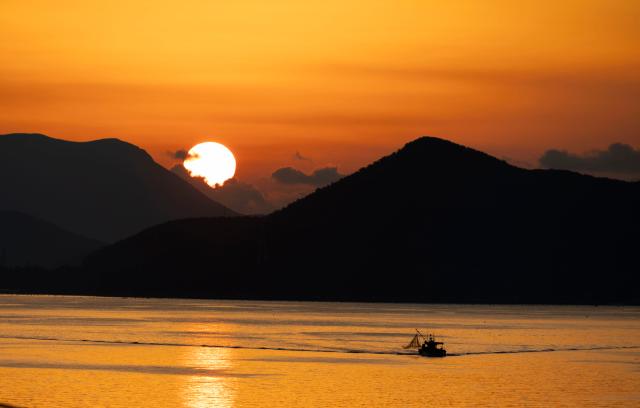 (251214) -- TONGYEONG, Dec. 14, 2025 (Xinhua) -- A fishing boat is seen during the sunrise in Tongyeong, South Korea, on Dec. 14, 2025. (Photo by Jun Hyosang/Xinhua)