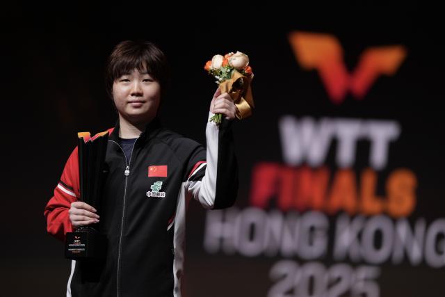 (251214) -- HONG KONG, Dec. 14, 2025 (Xinhua) -- Kuai Man of China poses during the awarding ceremony at the WTT Finals Hong Kong 2025 in Hong Kong, south China, Dec. 14, 2025. (Xinhua/Lui Siu Wai)