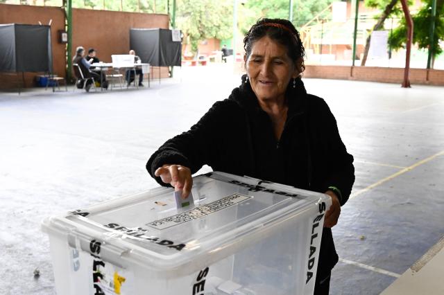 (251214) -- SANTIAGO, Dec. 14, 2025 (Xinhua) -- A local resident casts her vote at a polling station in Santiago, Chile, Dec. 14, 2025. Voting in the Chilean presidential runoff election opened on Sunday, with leftist candidate Jeannette Jara and Republican contender Jose Antonio Kast competing in the runoff. (Photo by Jorge Villegas/Xinhua)