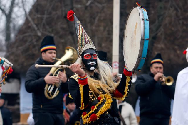 (251215) -- BUCHAREST, Dec. 15, 2025 (Xinhua) -- A masked member of a traditional dance group performs during the "White Flowers" festival of traditions and customs at the Village Museum in Bucharest, Romania, on Dec. 14, 2025. (Photo by Cristian Cristel/Xinhua)