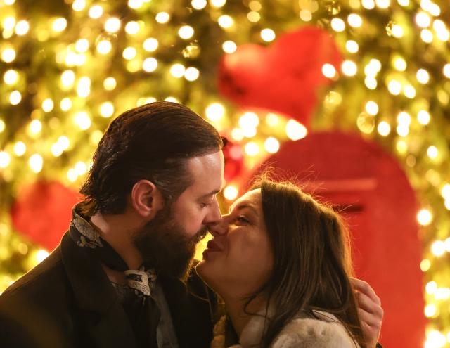 (251215) -- ROME, Dec. 15, 2025 (Xinhua) -- A couple poses for photos with Christmas lights near Via del Corso in Rome, Italy, Dec. 14, 2025. (Xinhua/Li Jing)