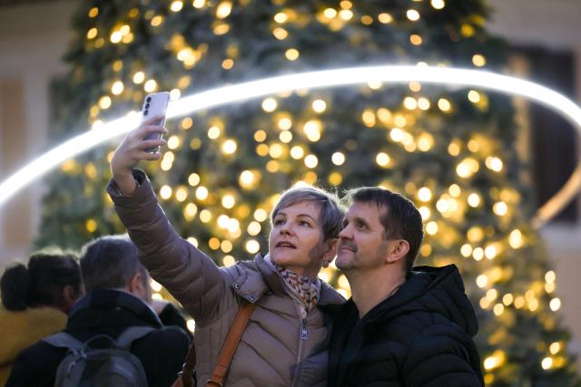 (251215) -- ROME, Dec. 15, 2025 (Xinhua) -- People take selfies with a Christmas tree at Piazza di Spagna in Rome, Italy, Dec. 14, 2025. (Xinhua/Li Jing)