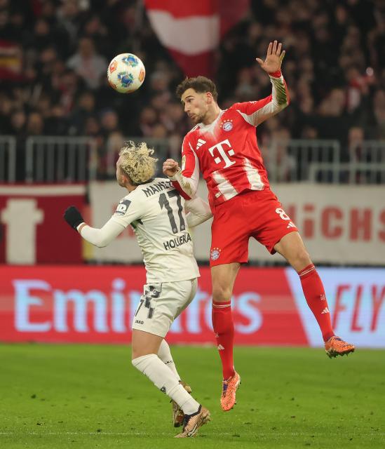 (251215) -- MUNICH, Dec. 15, 2025 (Xinhua) -- Leon Goretzka (R) of FC Bayern Munich and Benedict Hollerbach of FSV Mainz 05 head for the ball during the German first division Bundesliga football match between FC Bayern Munich and FSV Mainz 05 in Munich, Germany, Dec. 14, 2025. (Photo by Philippe Ruiz/Xinhua)