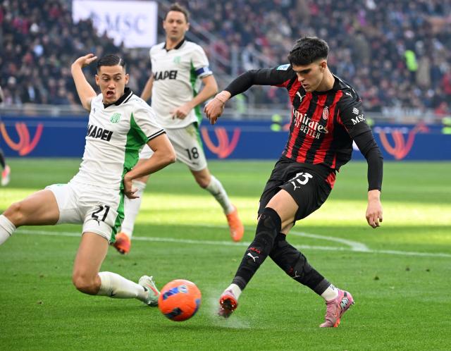 (251215) -- MILAN, Dec. 15, 2025 (Xinhua) -- AC Milan's Davide Bartesaghi (R) shoots and scores his second goal during a Serie A football match between AC Milan and Sassuolo in Milan, Italy, Dec. 14, 2025. (Photo by Alberto Lingria/Xinhua)