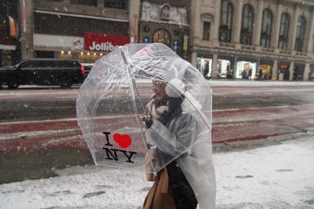 (251215) -- NEW YORK, Dec. 15, 2025 (Xinhua) -- A woman with an umbrella walks in snow on a street in New York, the United States, on Dec. 14, 2025. (Xinhua/Zhang Fengguo)