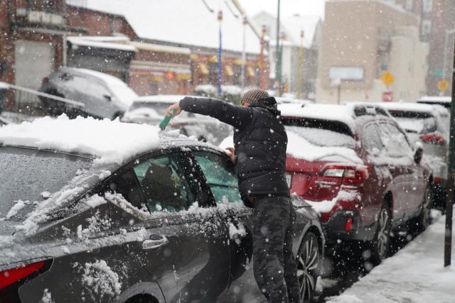 (251215) -- NEW YORK, Dec. 15, 2025 (Xinhua) -- A man clears snow on a vehicle on a street in New York, the United States, on Dec. 14, 2025. (Xinhua/Zhang Fengguo)