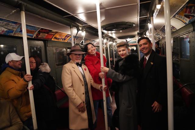 (251215) -- NEW YORK, Dec. 15, 2025 (Xinhua) -- People in vintage clothing take a ride on the Holiday Nostalgia Train in New York City, the United States, on Dec. 14, 2025.
  Holiday Nostalgia Train, vintage 1930s train cars, is running every Sunday in December to celebrate the holiday season here in New York, taking passengers to step back in time. (Xinhua/Zhang Fengguo)