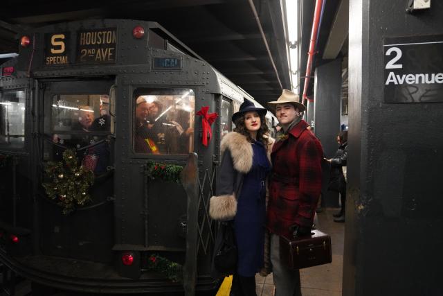 (251215) -- NEW YORK, Dec. 15, 2025 (Xinhua) -- People in vintage clothing pose in front of the Holiday Nostalgia Train in New York City, the United States, on Dec. 14, 2025.
  Holiday Nostalgia Train, vintage 1930s train cars, is running every Sunday in December to celebrate the holiday season here in New York, taking passengers to step back in time. (Xinhua/Zhang Fengguo)