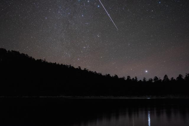 (251215) -- KANGDING, Dec. 15, 2025 (Xinhua) -- This photo taken on Dec. 14, 2025 shows the Geminid meteor shower in the sky over Niujiaohai Lake in Ganluo County, southwest China's Sichuan Province.
  The Geminid meteor shower, one of the most spectacular meteor showers of the year, reached its peak on Dec. 14. (Xinhua/Jiang Hongjing)