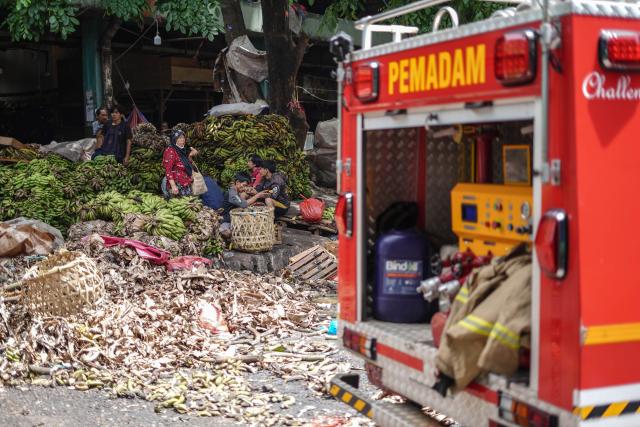 (251215) -- JAKARTA, Dec. 15, 2025 (Xinhua) -- Workers relocate bananas to a secure zone after a fire broke out at Pasar Induk Kramat Jati, a wholesale fruit and vegetable market in Jakarta, Indonesia, Dec. 15, 2025. (Photo by B. Nugraha/Xinhua)