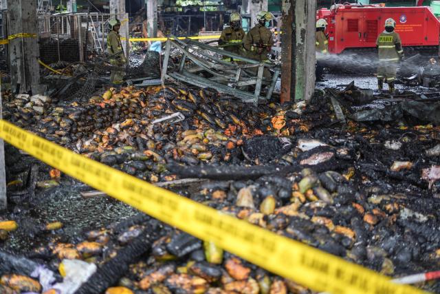 (251215) -- JAKARTA, Dec. 15, 2025 (Xinhua) -- Firefighters work on site after a fire broke out at Pasar Induk Kramat Jati, a wholesale fruit and vegetable market in Jakarta, Indonesia, Dec. 15, 2025. (Photo by B. Nugraha/Xinhua)