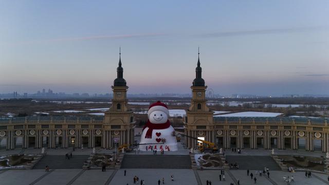 (251215) -- HARBIN, Dec. 15, 2025 (Xinhua) -- A drone photo shows a giant snowman at the Qunli music park in Harbin, northeast China's Heilongjiang Province, Dec. 15, 2025. This year's giant snowman, 19 meters in height and made with some 3,000 cubic meters of snow, is one meter taller than that of last year. (Xinhua/Wang Song)