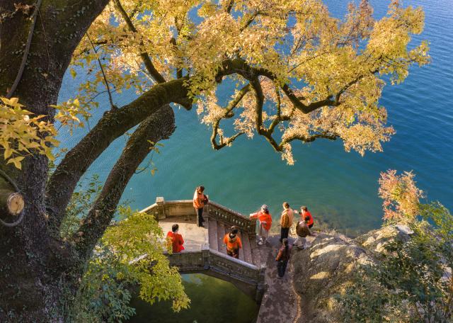 (251216) -- BEIJING, Dec. 16, 2025 (Xinhua) -- An aerial drone photo taken on Nov. 23, 2025 shows tourists enjoying sightseeing on an arch bridge near Wenchang pavilion in Ningbo City, east China's Zhejiang Province. (Photo by Hu Xuejun/Xinhua)