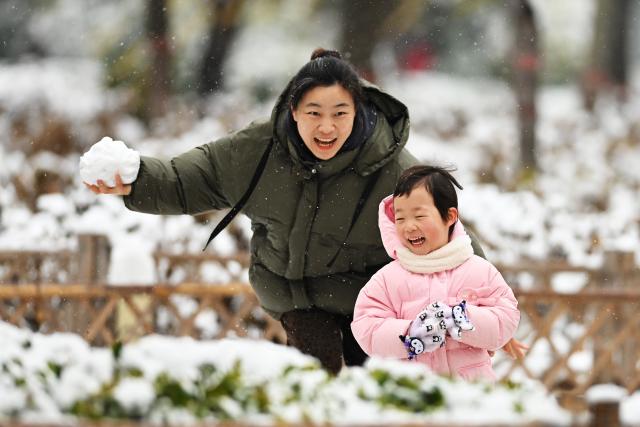 (251216) -- BEIJING, Dec. 16, 2025 (Xinhua) -- A mother and her child play with snow at Jinghe Park in Tengzhou City, east China's Shandong Province, Dec. 13, 2025. (Photo by Li Zhijun/Xinhua)