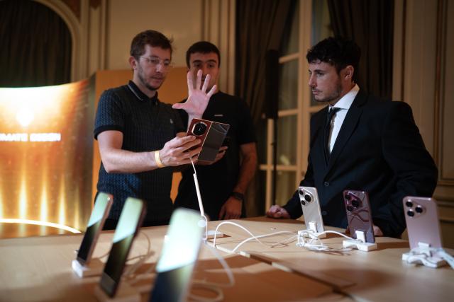 (251216) -- BUENOS AIRES, Dec. 16, 2025 (Xinhua) -- People visit the Huawei product launch event in Buenos Aires, Argentina, Dec. 15, 2025. Chinese tech giant Huawei launched a series of new cellphones and equipment on Monday in Buenos Aires, marking its return to the Argentine smartphone market after six years. (Photo by Martin Zabala/Xinhua)