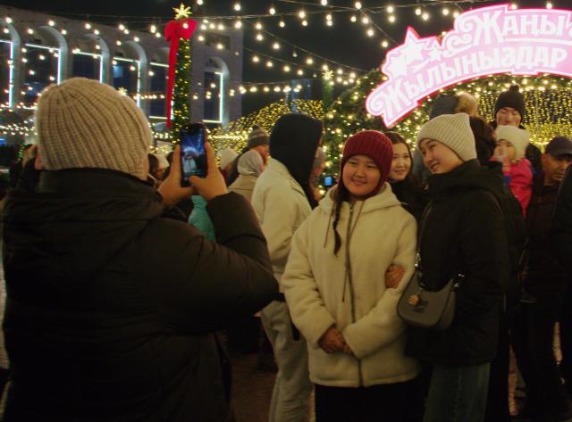 (251216) -- BISHKEK, Dec. 16, 2025 (Xinhua) -- People take photos during the New Year tree lighting ceremony in Bishkek, Kyrgyzstan, Dec. 15, 2025. (Photo by Liu Xiaowan/Xinhua)
