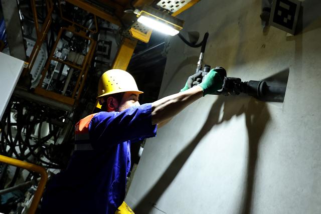 (251216) -- SHANGHAI, Dec. 16, 2025 (Xinhua) -- A worker screws a bolt tight at the construction site of the Chongming-Taicang tunnel, part of the Shanghai-Chongqing-Chengdu High-Speed Railway, under Yangtze River, on Dec. 16, 2025. The ongoing excavation of the tunnel under Yangtze River, carried out by the world's largest diameter high-speed rail shield tunneling machine the "Linghang" that is independently developed by China, has exceeded the 10,000-meter mark on Tuesday, which laid a solid foundation for the completion of the tunnel.
   The 14.25 km single-hole double-track tunnel starts from Chongming of east China's Shanghai Municipality to Taicang in east China's Jiangsu Province, with the rail designed speed of 350 kilometers per hour. (Xinhua/Fang Zhe)