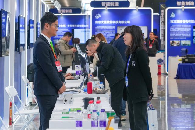 (251216) -- NANJING, Dec. 16, 2025 (Xinhua) -- Participants visit an exhibition area of the 2025 annual conference of the Cross-Strait CEO Summit in Nanjing, east China's Jiangsu Province, Dec. 16, 2025. The 2025 annual conference of the Cross-Strait CEO Summit opened here Tuesday. About 800 people from the Chinese mainland and Taiwan gathered on Tuesday in Nanjing to discuss cross-Strait industrial transformation, innovation and cooperation. (Xinhua/Li Bo)