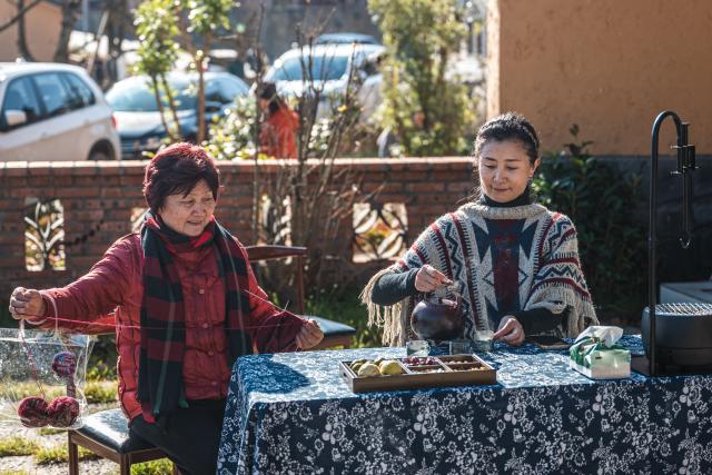 (251216) -- QUJING, Dec. 16, 2025 (Xinhua) -- People enjoy leisure time in the Huangba neighborhood of Qujing City, southwest China's Yunnan Province, Dec. 16, 2025. The Huangba neighborhood is one of the local model travel destinations promoted by Qujing City, which has in recent years made great efforts to help transform the local ecological advantages into tourism resources. A number of livable and business-friendly villages are built here for rural revitalization. (Xinhua/Wang Guansen)