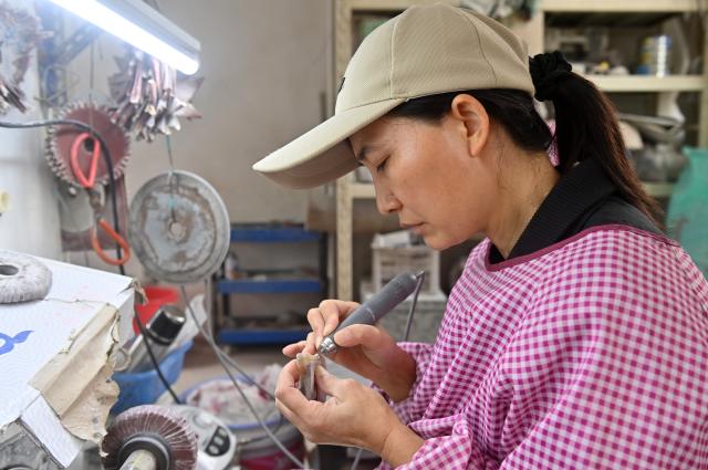 (251216) -- NANNING, Dec. 16, 2025 (Xinhua) -- A worker processes an ox corn product in Wuling Town of Binyang County, south China's Guangxi Zhuang Autonomous Region, Dec. 16, 2025. The Wuling ox horn carving technique of Binyang County is a local traditional craft with a history of over three centuries. In recent years, Binyang County has been encouraging industrial innovation in the development of ox corn products such as combs, massage hammers, tea sets and pen caps. Every year, some six million ox horn products are produced in the county with considerable market acceptance. (Xinhua/Lu Boan)