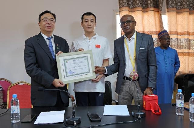 (251216) -- ANTANANARIVO, Dec. 16, 2025 (Xinhua) -- Chinese ambassador to the Comoros Huang Zheng (1st L) and Comorian Minister of Health and Social Protection Ahamadi Sidi Nahouda (2nd R) jointly present a certificate of honor to a member of the 16th Chinese medical team to the Comoros at a ceremony marking the arrival of the 17th Chinese medical team in the Comoros and the departure of the previous team in Moroni, capital of the Comoros, Dec. 15, 2025. TO GO WITH "17th Chinese medical team arrives in Comoros to boost health cooperation" (17th Chinese medical team in the Comoros/Handout via Xinhua)