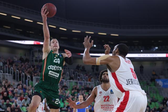 (251217) -- LJUBLJANA, Dec. 17, 2025 (Xinhua) -- David Skara (L) of Cedevita Olimpija Ljubljana goes for a layup during the BKT EuroCup 2025/26 11th round basketball match between Cedevita Olimpija Ljubljana and Hapoel Midtown Jerusalem in Ljubljana, Slovenia, on Dec. 16, 2025. (Photo by Zeljko Stevanic/Xinhua)